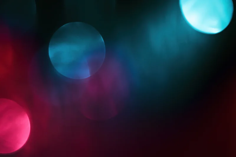 Abstract bokeh of colored stage lights glowing in dark atmosphere