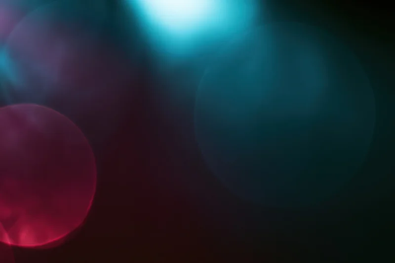 Abstract stage lighting bokeh with overlapping colored light circles on dark background