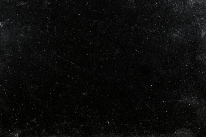 Aged black film negative surface with scattered dust particles and scratches
