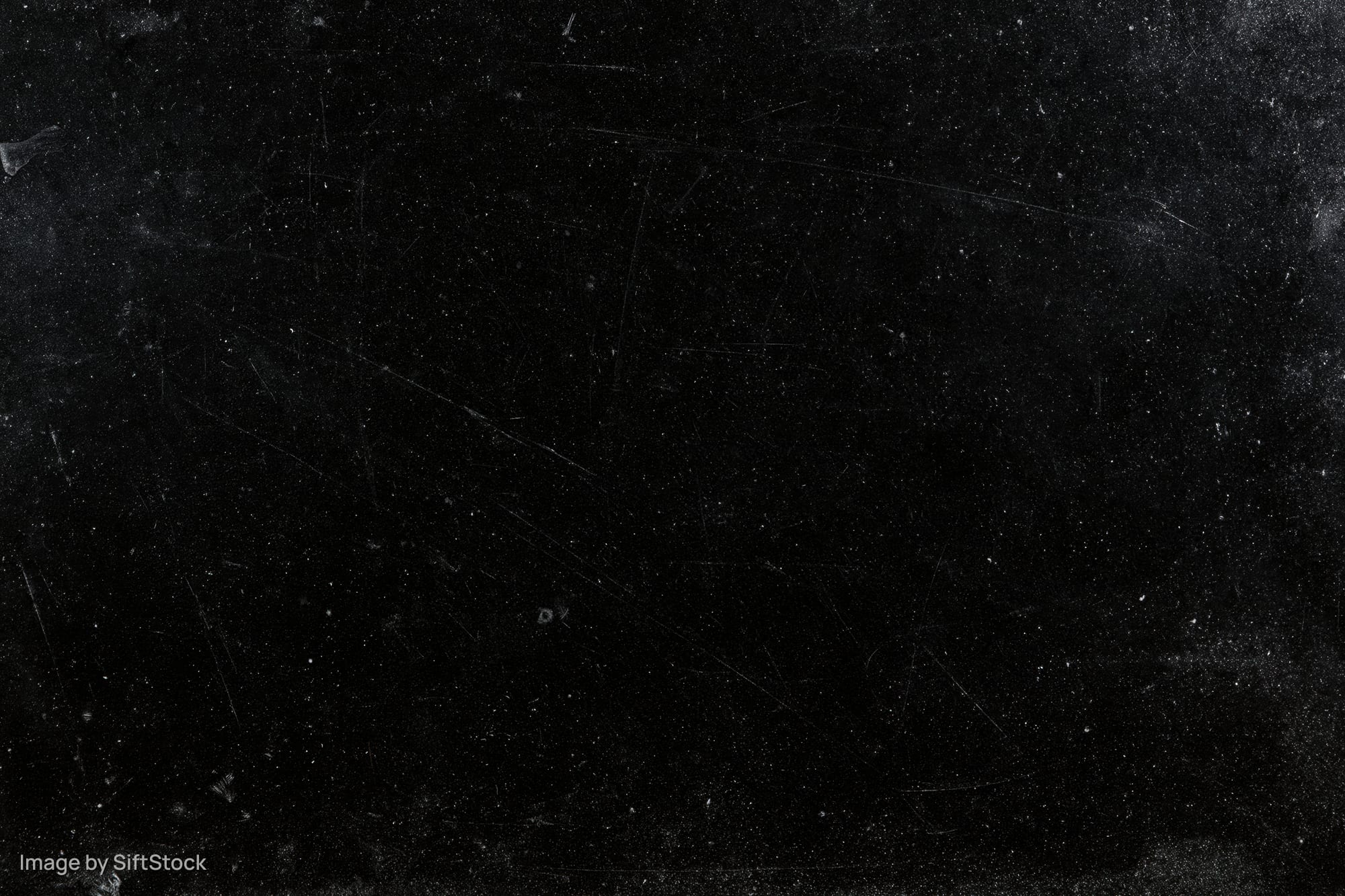 Aged black film negative surface with scattered dust particles and scratches