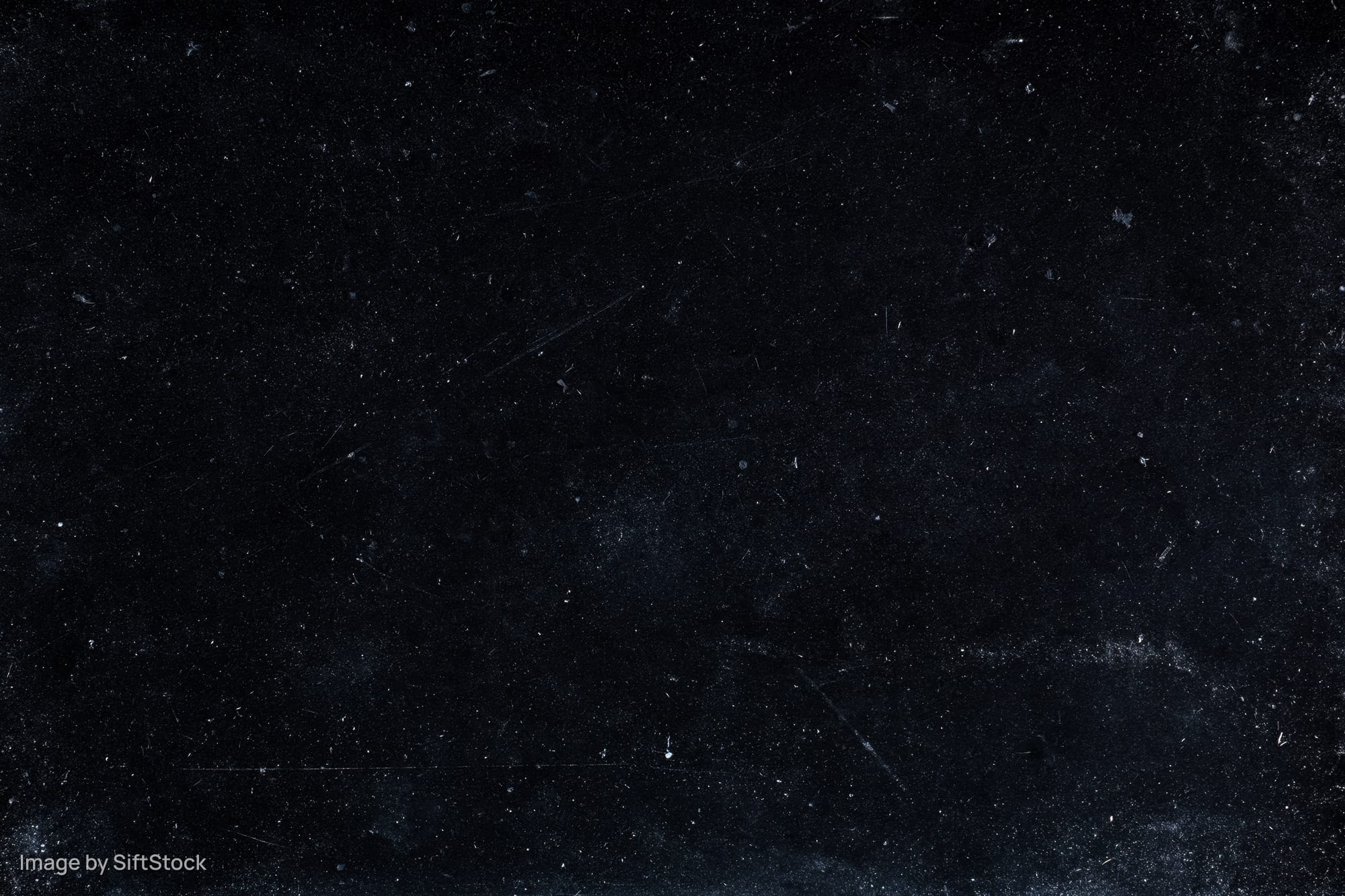 Aged black film negative surface with scattered dust particles and scratches