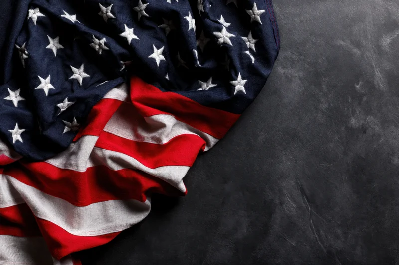 American flag draped on dark surface with copyspace