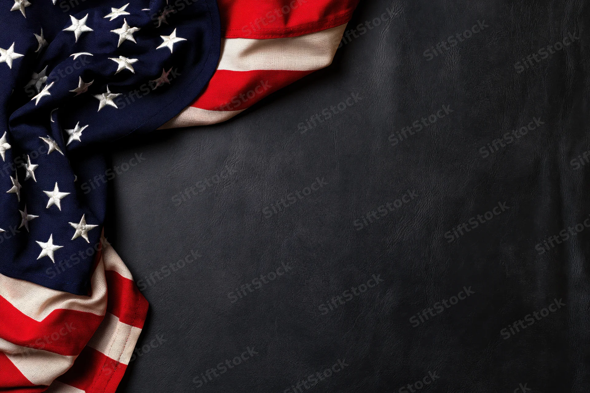 American flag draped in corner on dark leather surface with copyspace