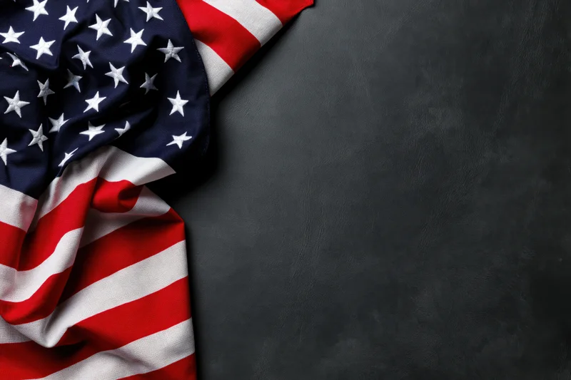 American flag draped in corner on dark textured surface with copyspace