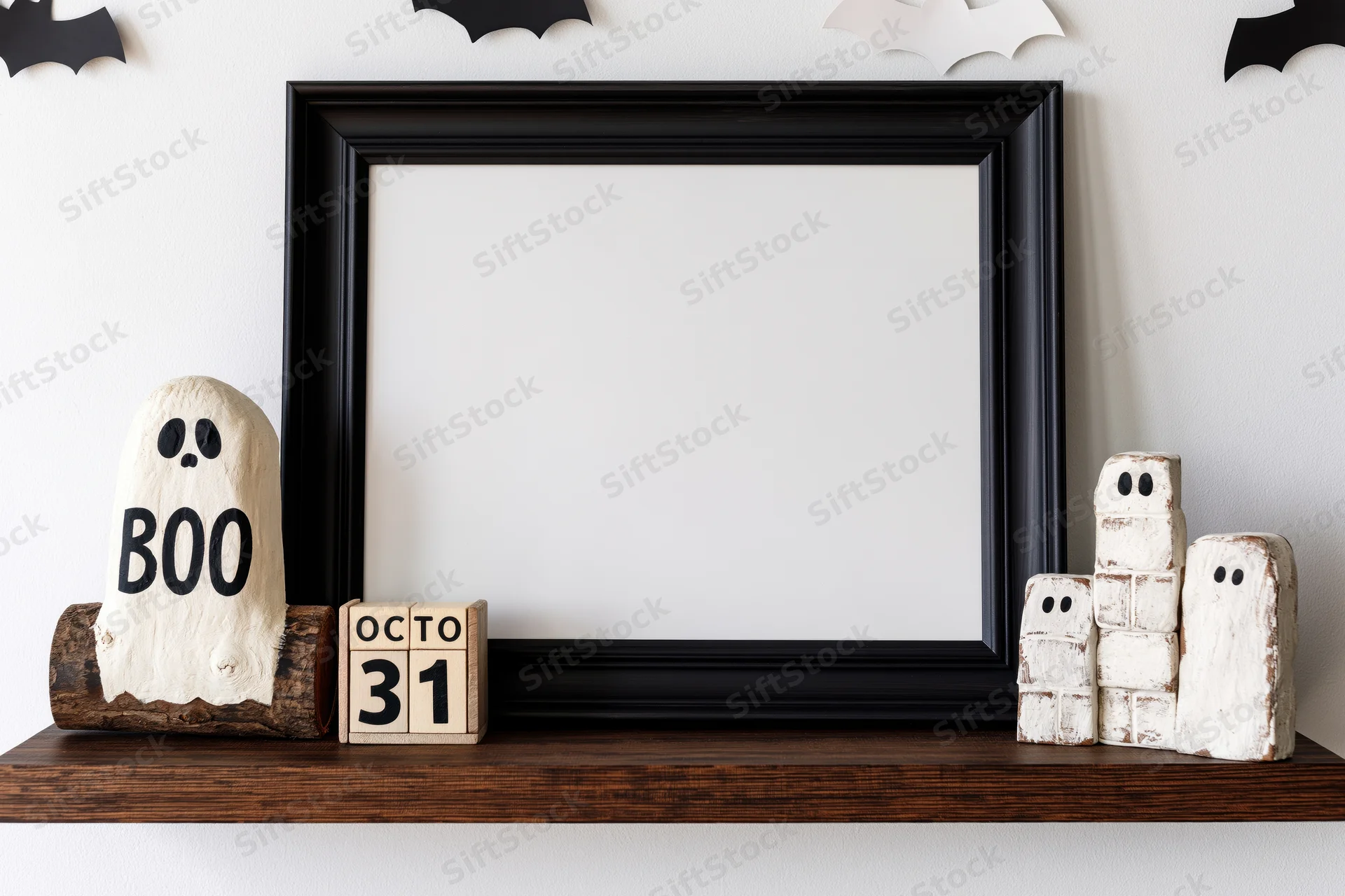 Black frame on wooden shelf with halloween ghosts and bats, october 31 calendar blocks, white wall background