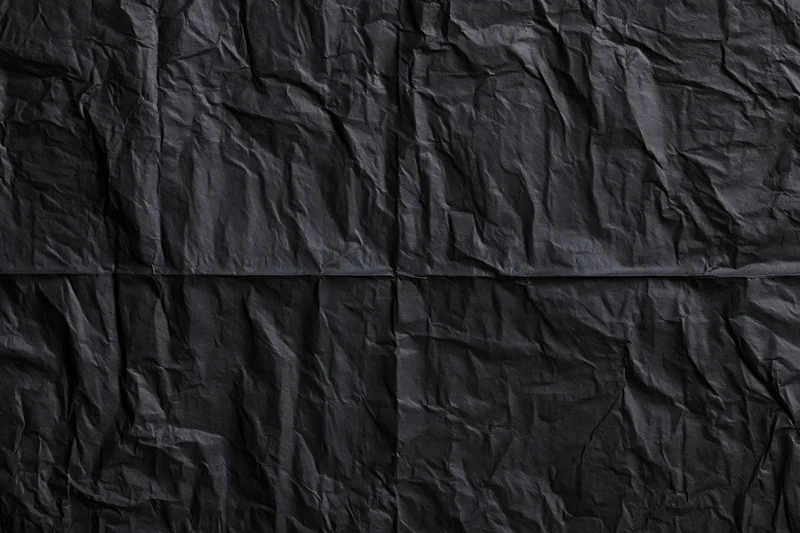 Crumpled black wheat-paste poster paper in flat lay closeup