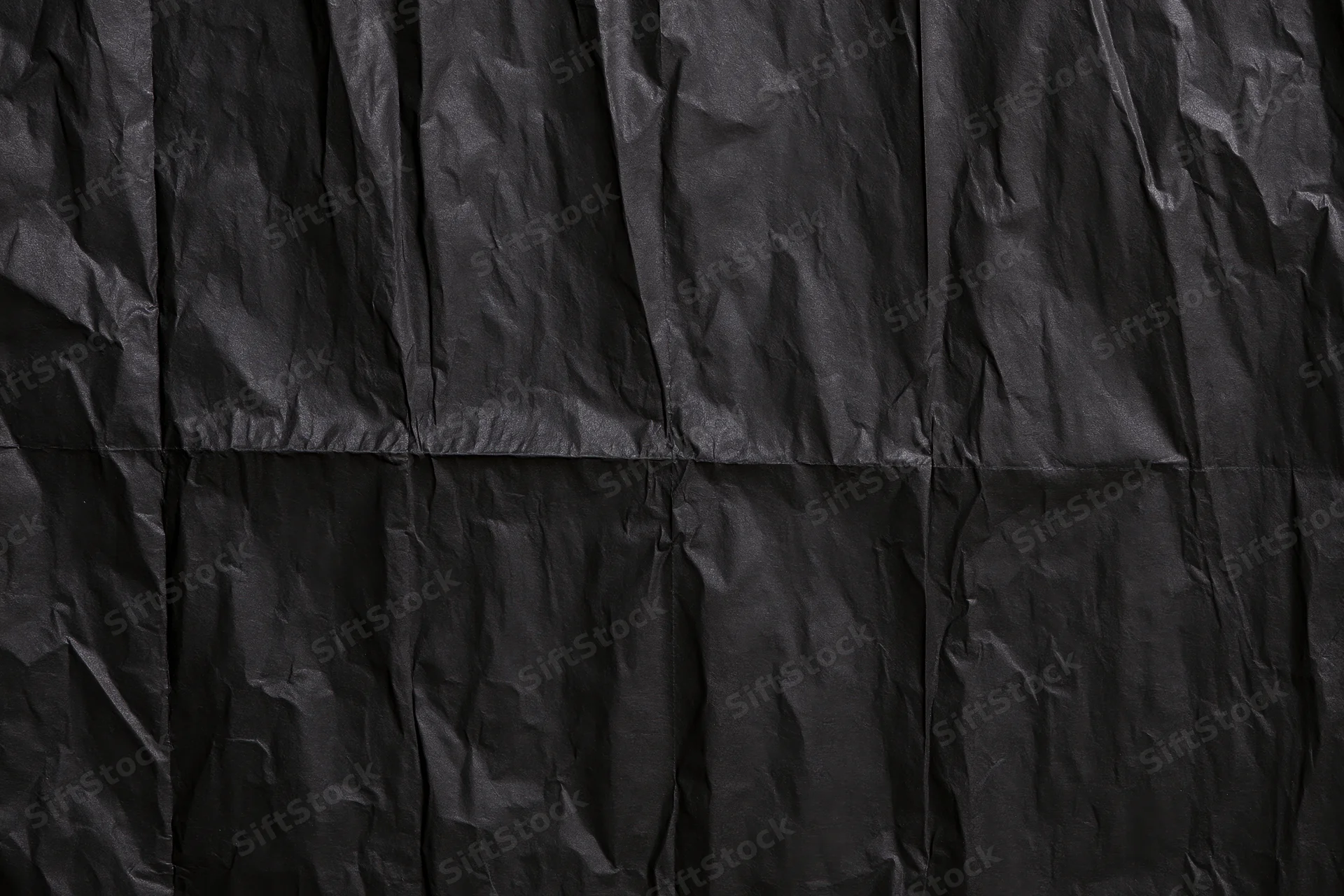 Crumpled black paper texture in flat lay view