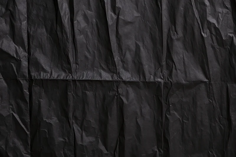 Crumpled black paper texture in flat lay view