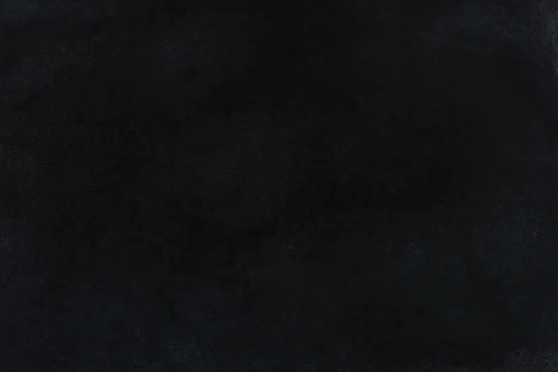 Close-up of a dark black velvet surface with soft texture and subtle grain
