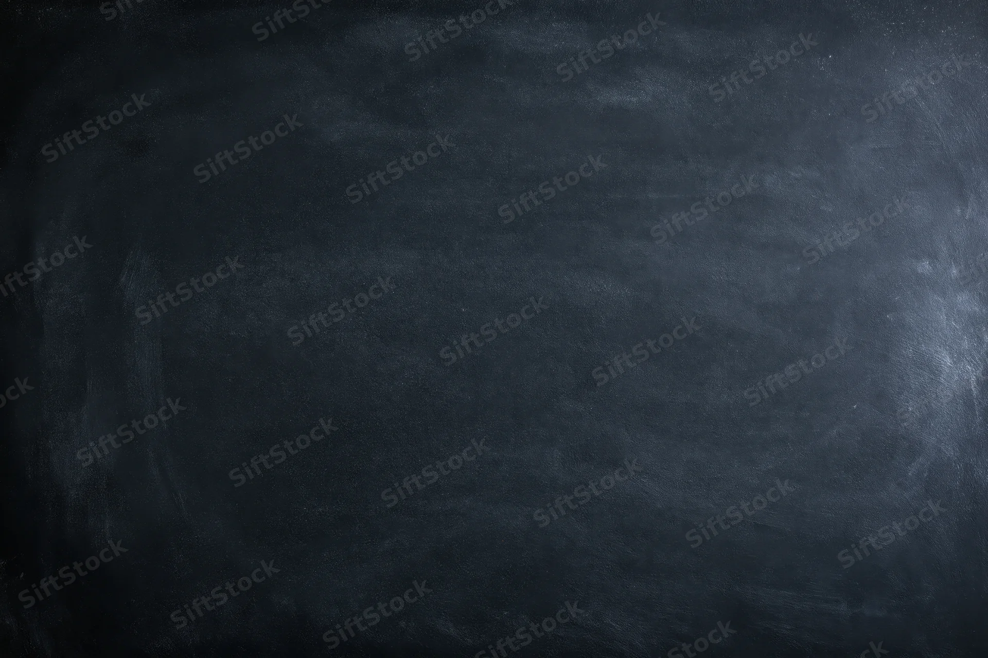 Close-up of a dark chalkboard surface with smudged texture and faint marks