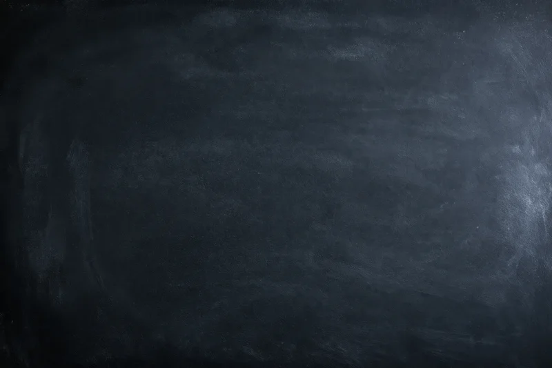 Close-up of a dark chalkboard surface with smudged texture and faint marks