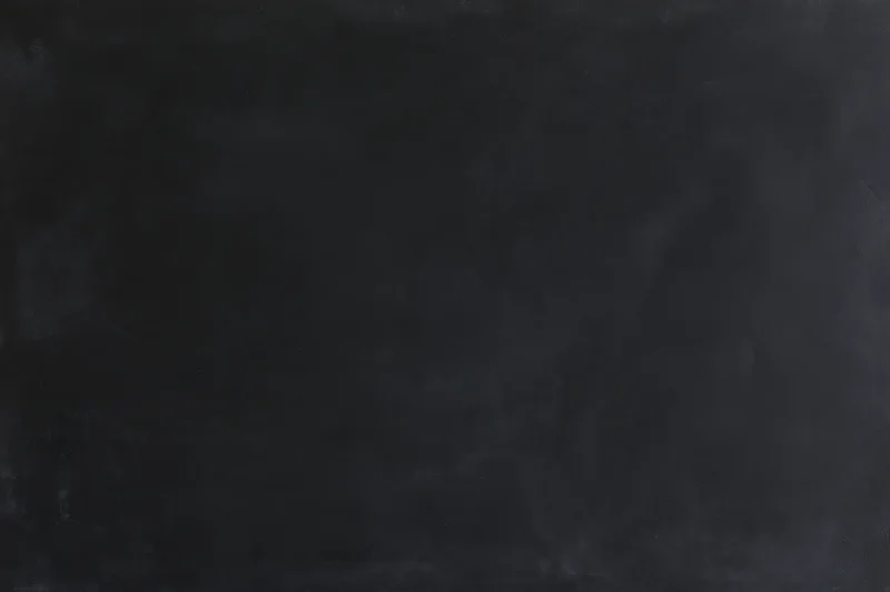 Close-up of a dark empty chalkboard surface in a classroom setting