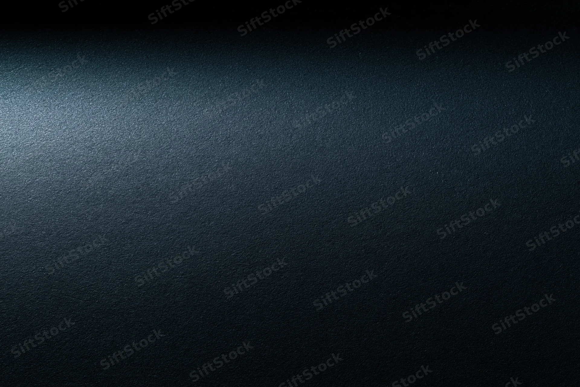 Close-up of a dark charcoal matte surface with subtle texture and gradient lighting