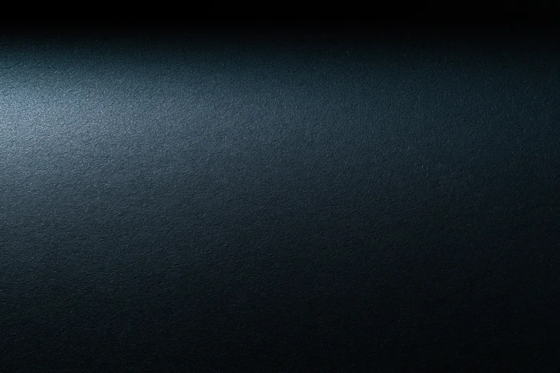 Close-up of a dark charcoal matte surface with subtle texture and gradient lighting
