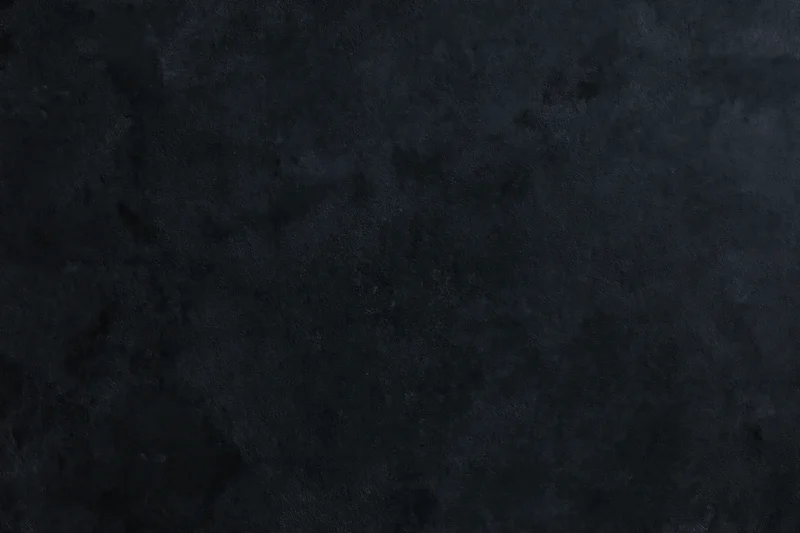 Dark textured concrete wall surface in close-up flat lay view