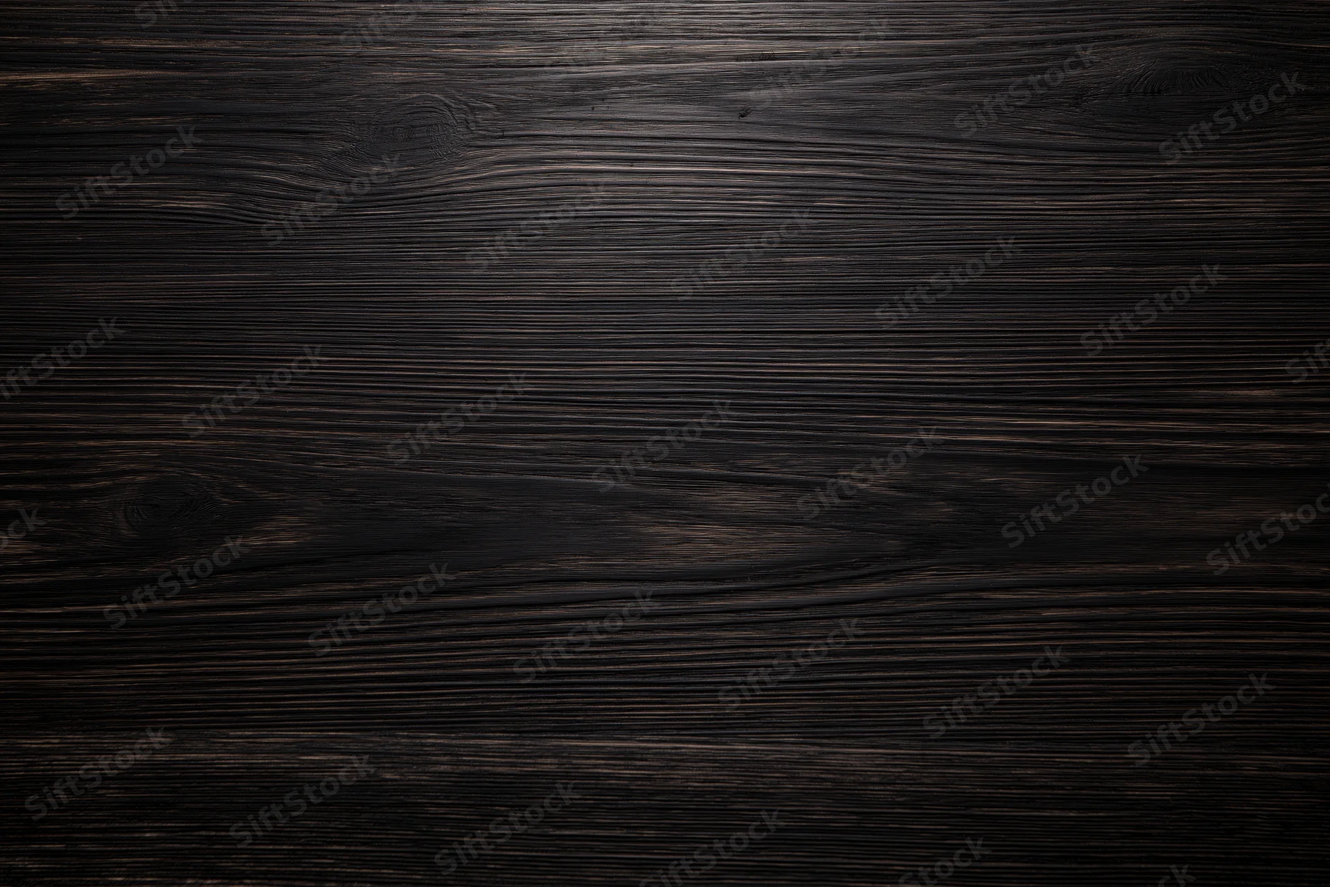 Close-up of dark ebony wood surface with visible grain pattern filling the frame