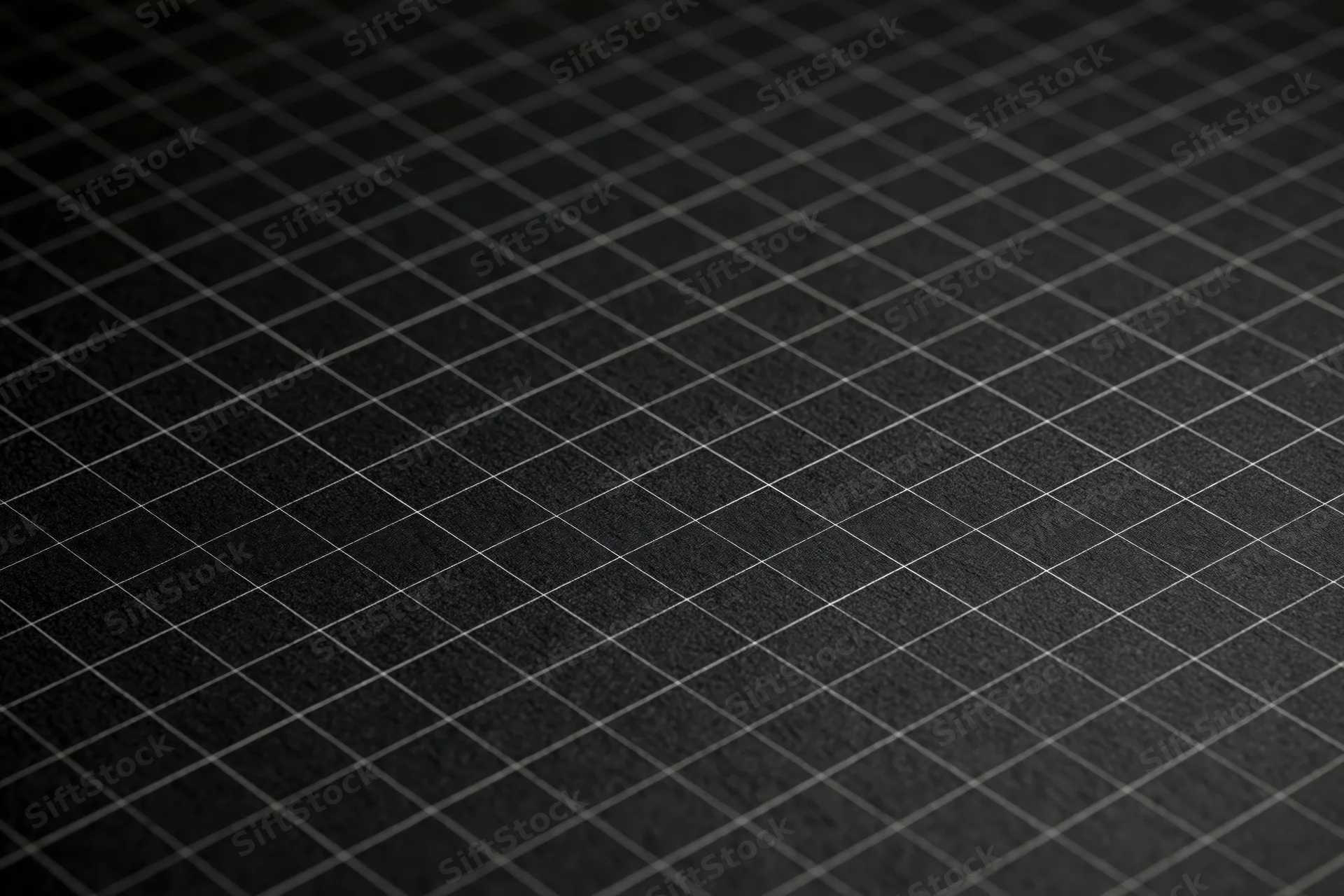 Close-up flat lay of dark matte black graph paper surface with grid pattern