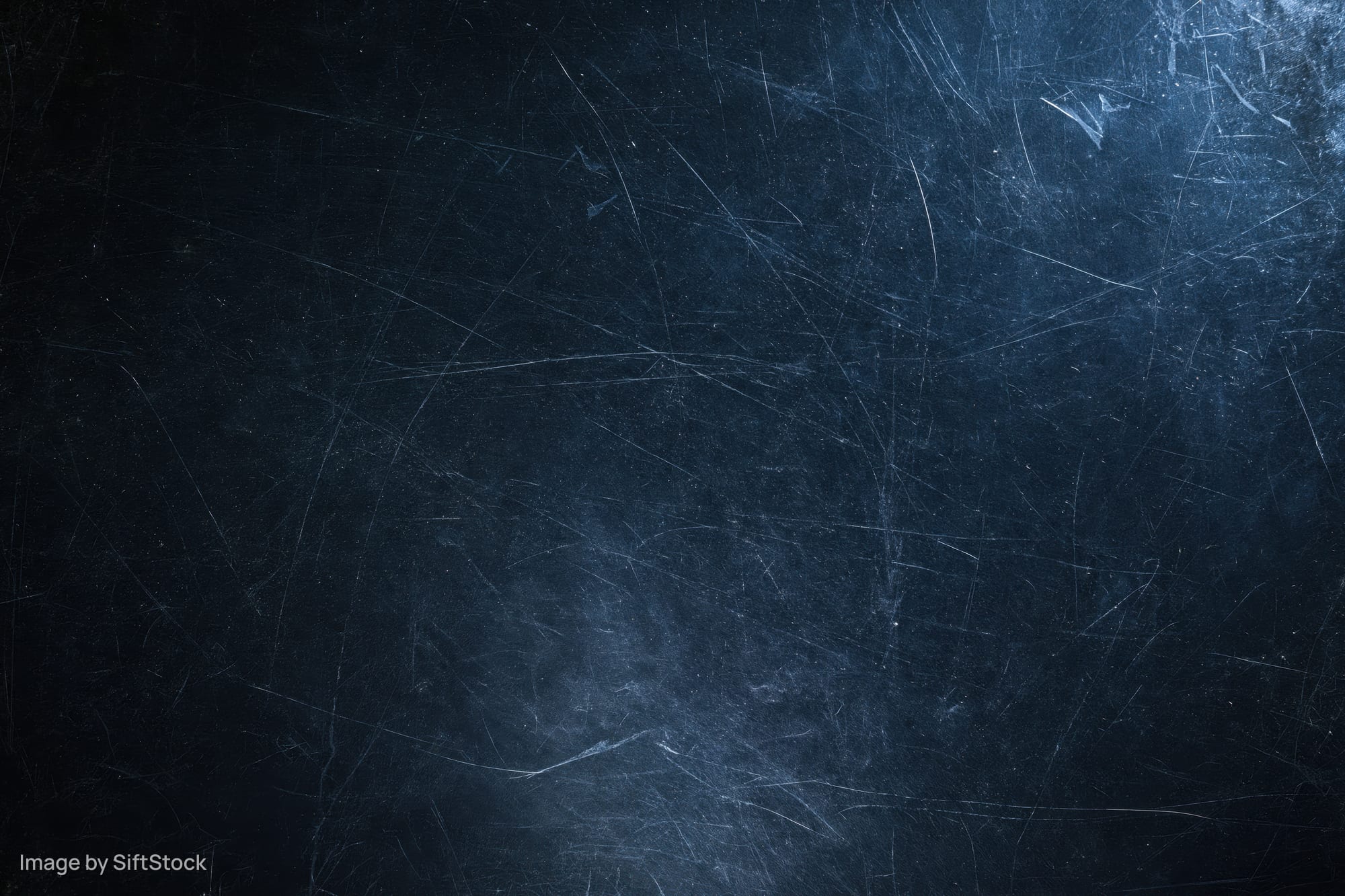 Close-up of a dark scratched matte surface with visible wear and texture