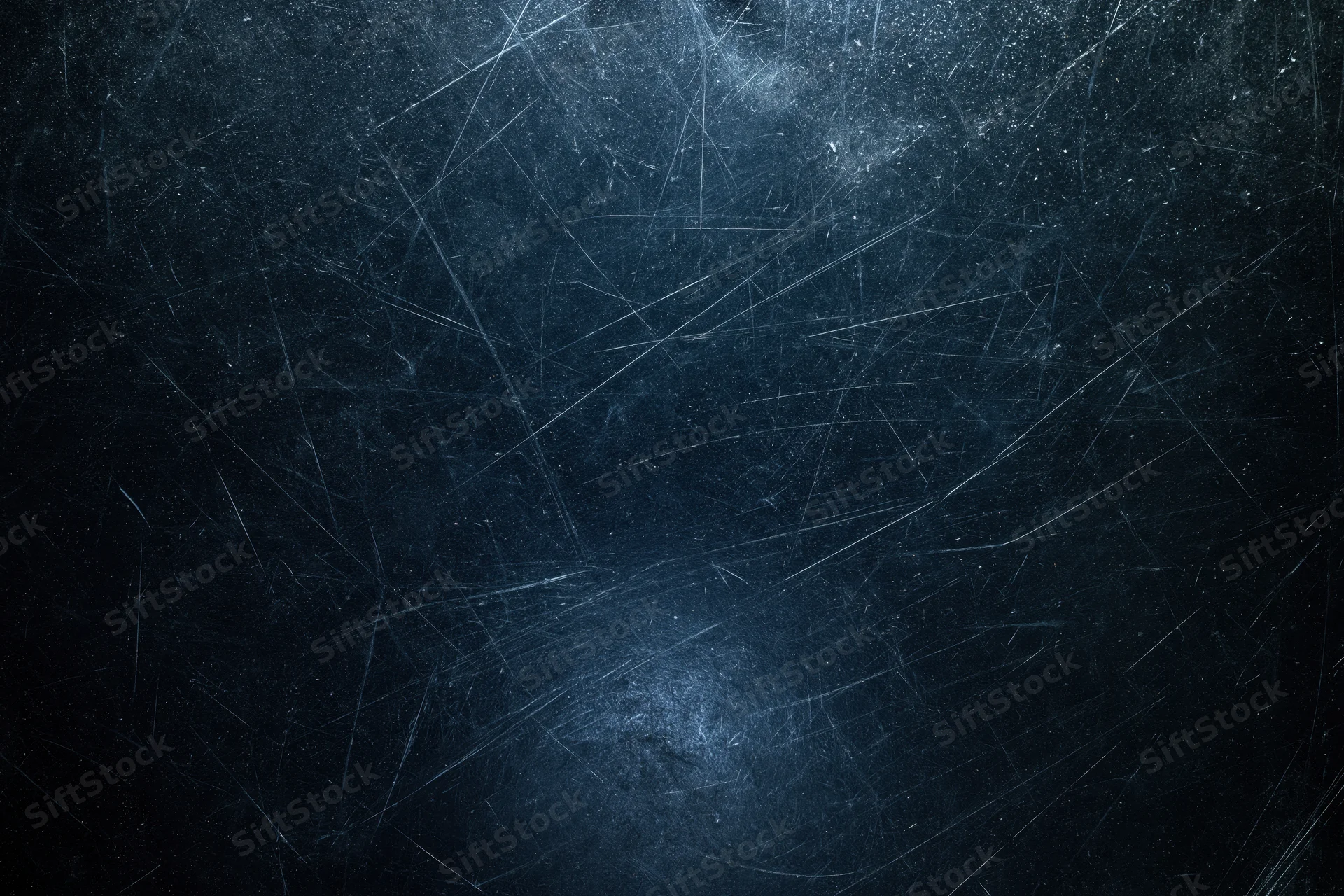 Close-up of a dark scratched matte surface with visible wear and texture