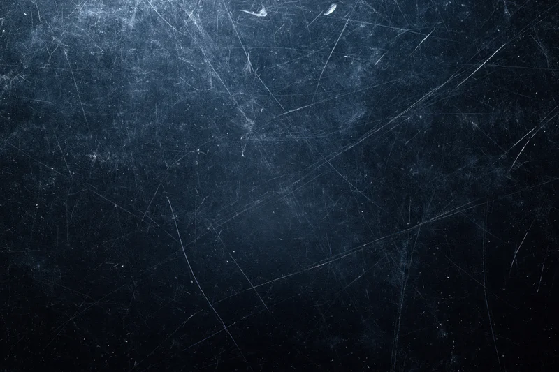 Close-up of a dark scratched matte surface filling the frame