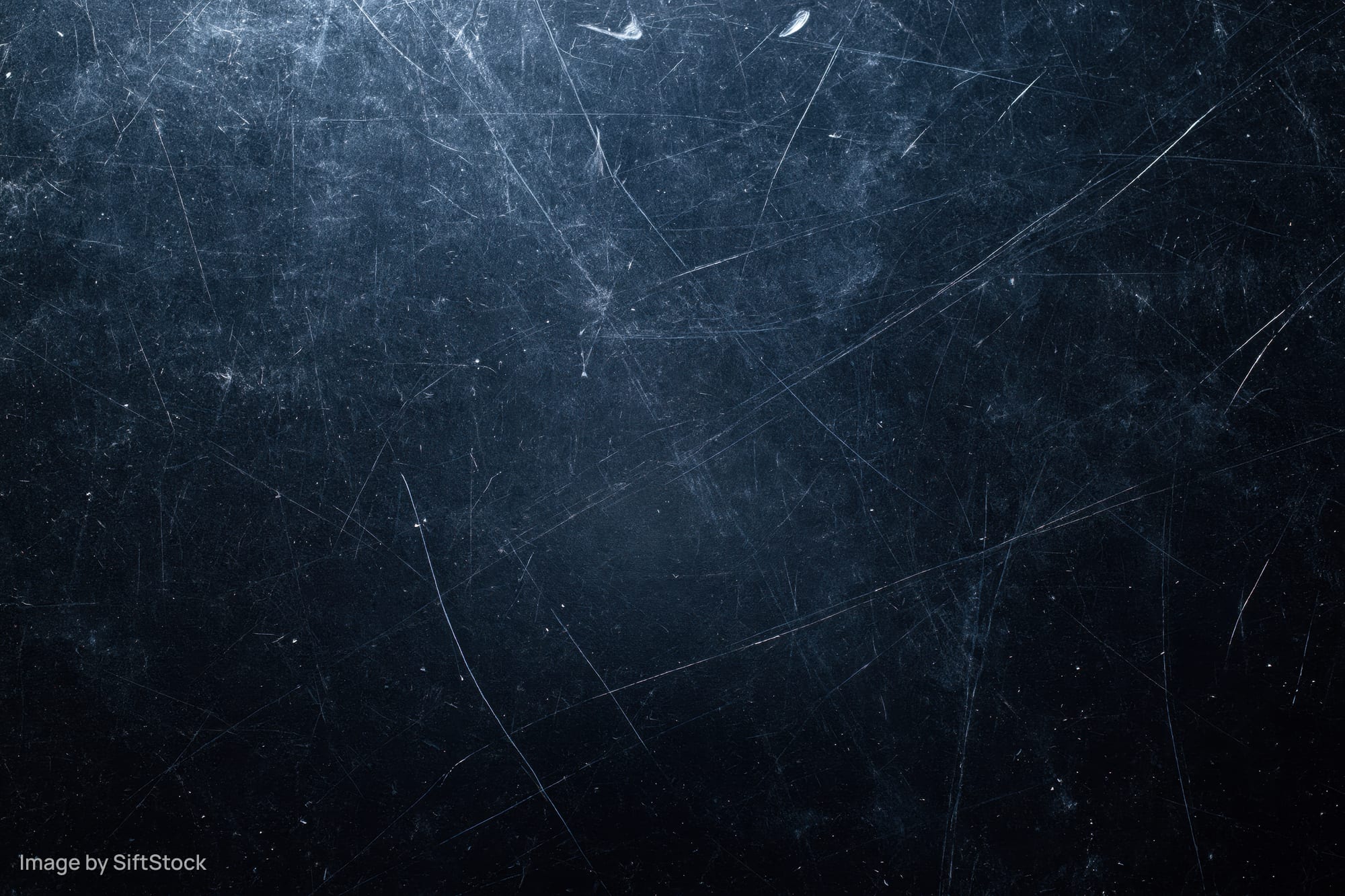 Close-up of a dark scratched matte surface filling the frame