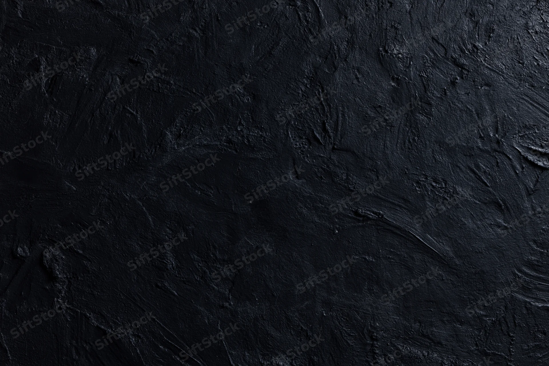 Close-up of dark textured wall surface with rough uneven finish