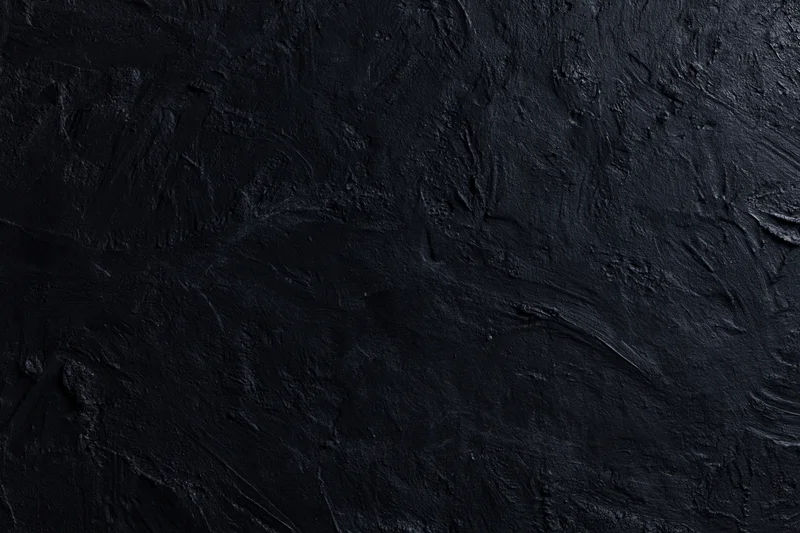 Close-up of dark textured wall surface with rough uneven finish
