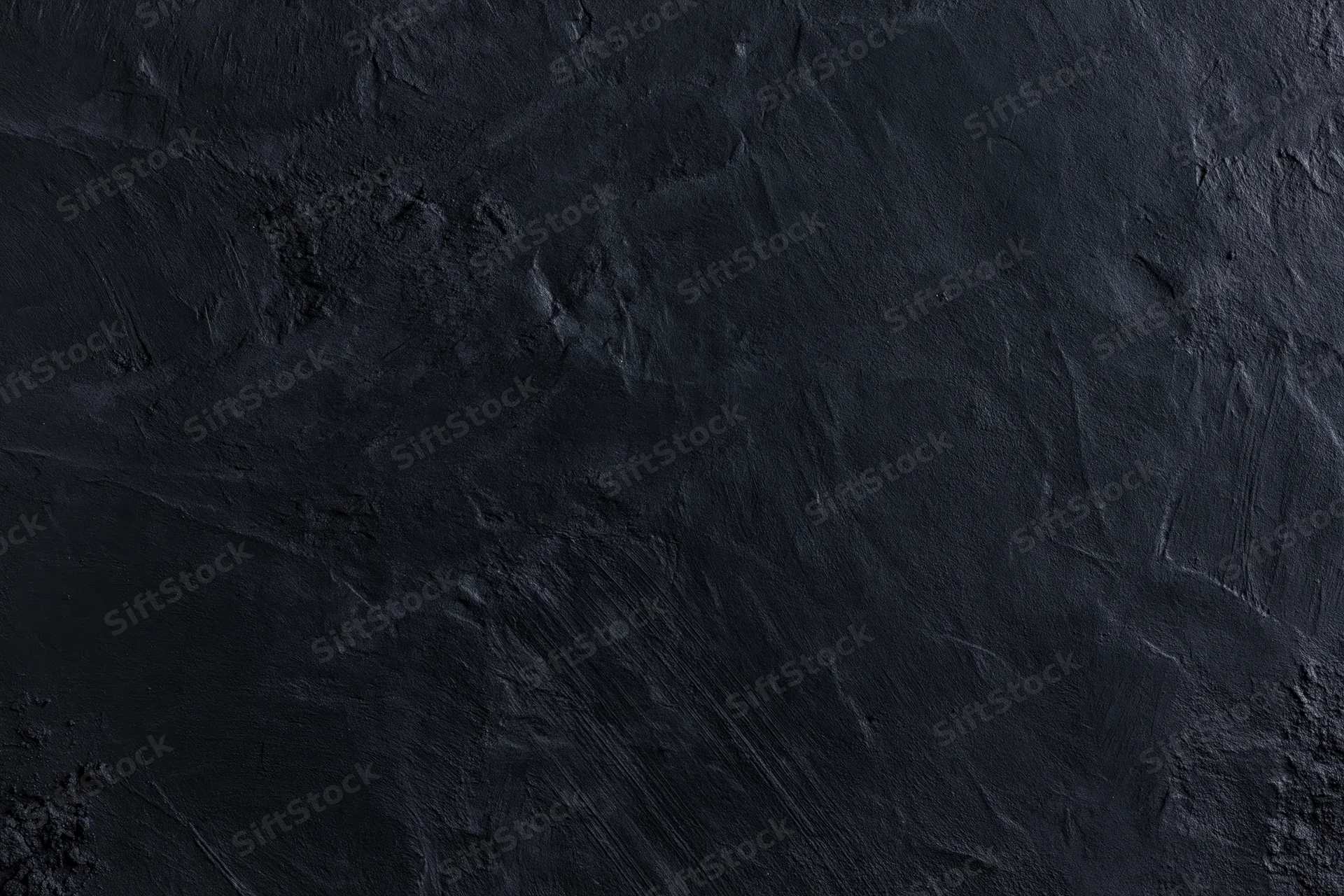 Close-up of dark textured wall surface with rough uneven finish