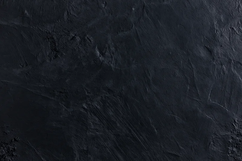 Close-up of dark textured wall surface with rough uneven finish