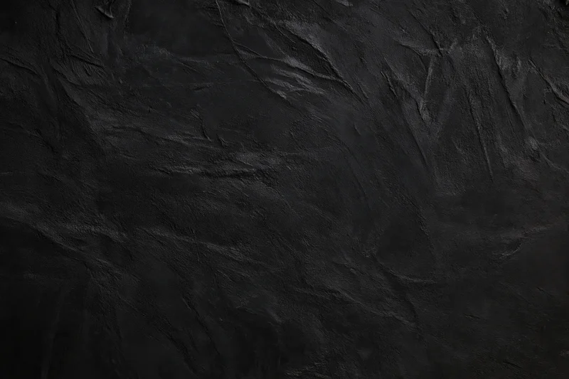 Close-up of dark textured wall surface with rough uneven finish