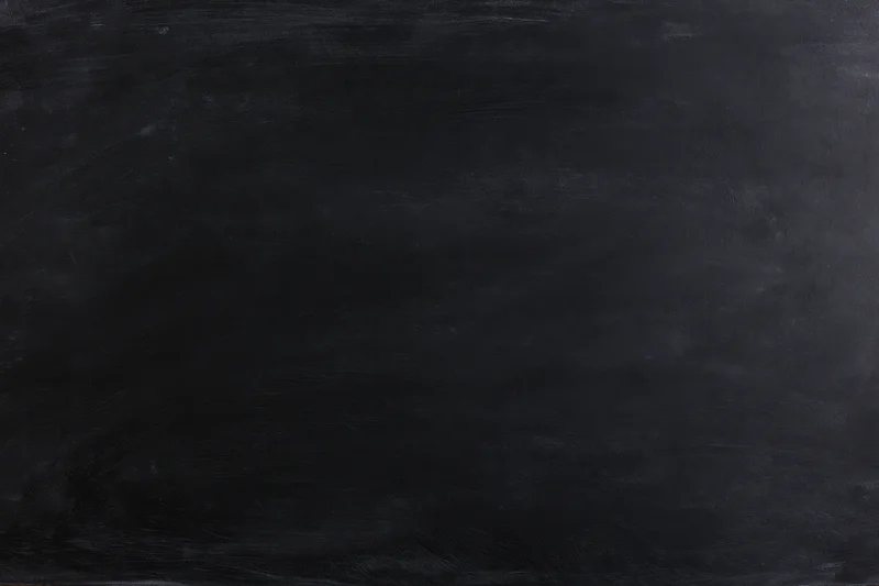 Close-up flat lay of a matte black chalkboard surface filling the frame with subtle texture and even lighting