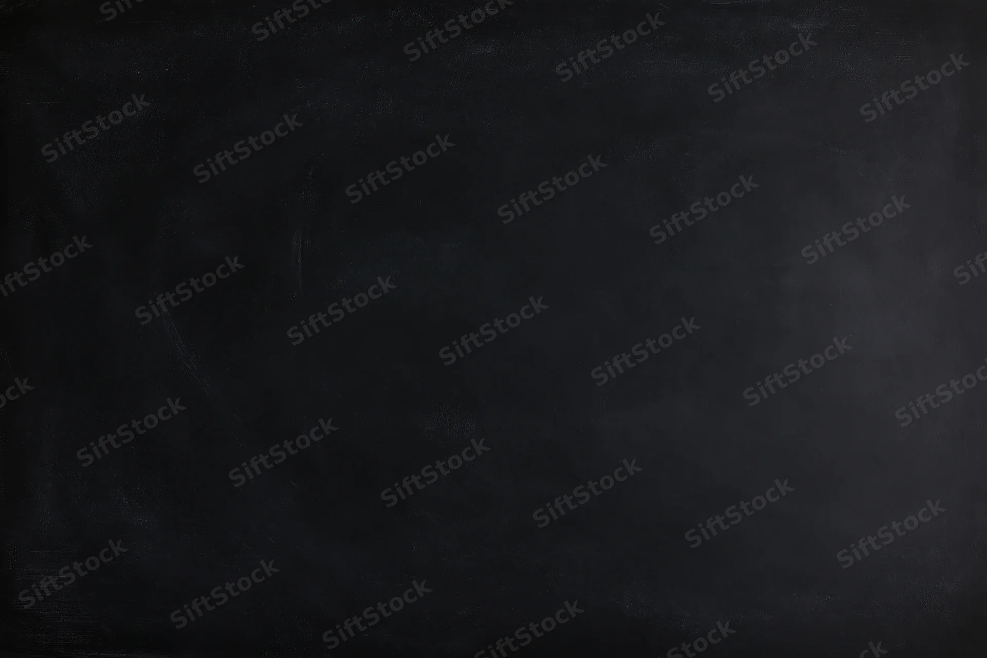 Close-up of a matte black chalkboard surface filling the frame with subtle texture and smudges