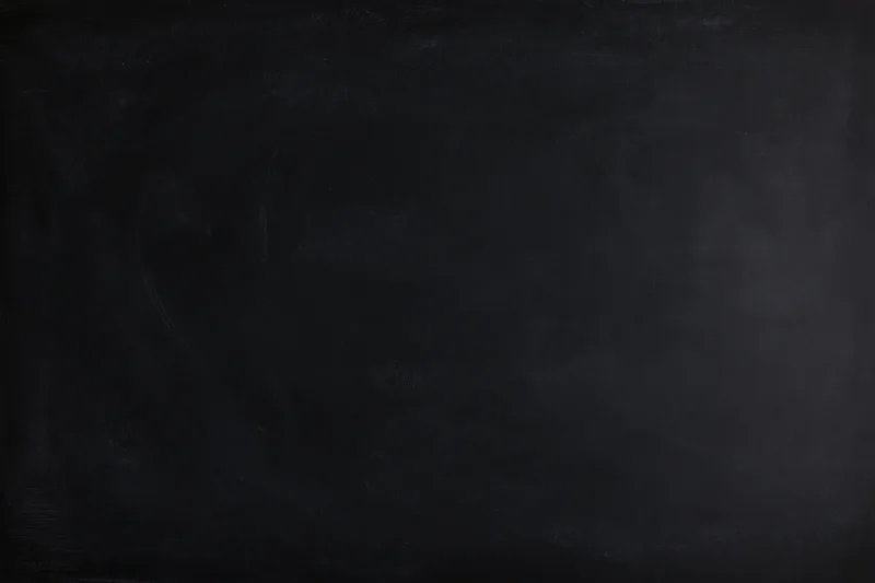 Close-up of a matte black chalkboard surface filling the frame with subtle texture and smudges