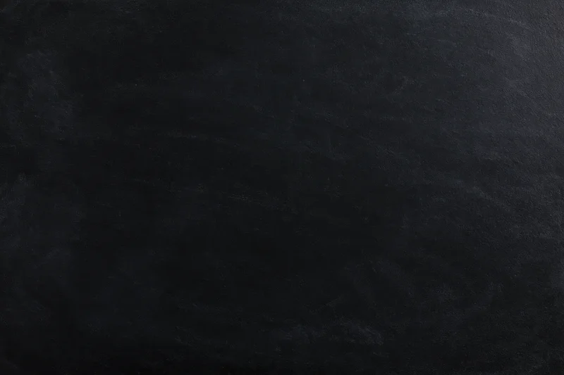 Close-up flat lay of a matte black chalkboard surface filling the frame