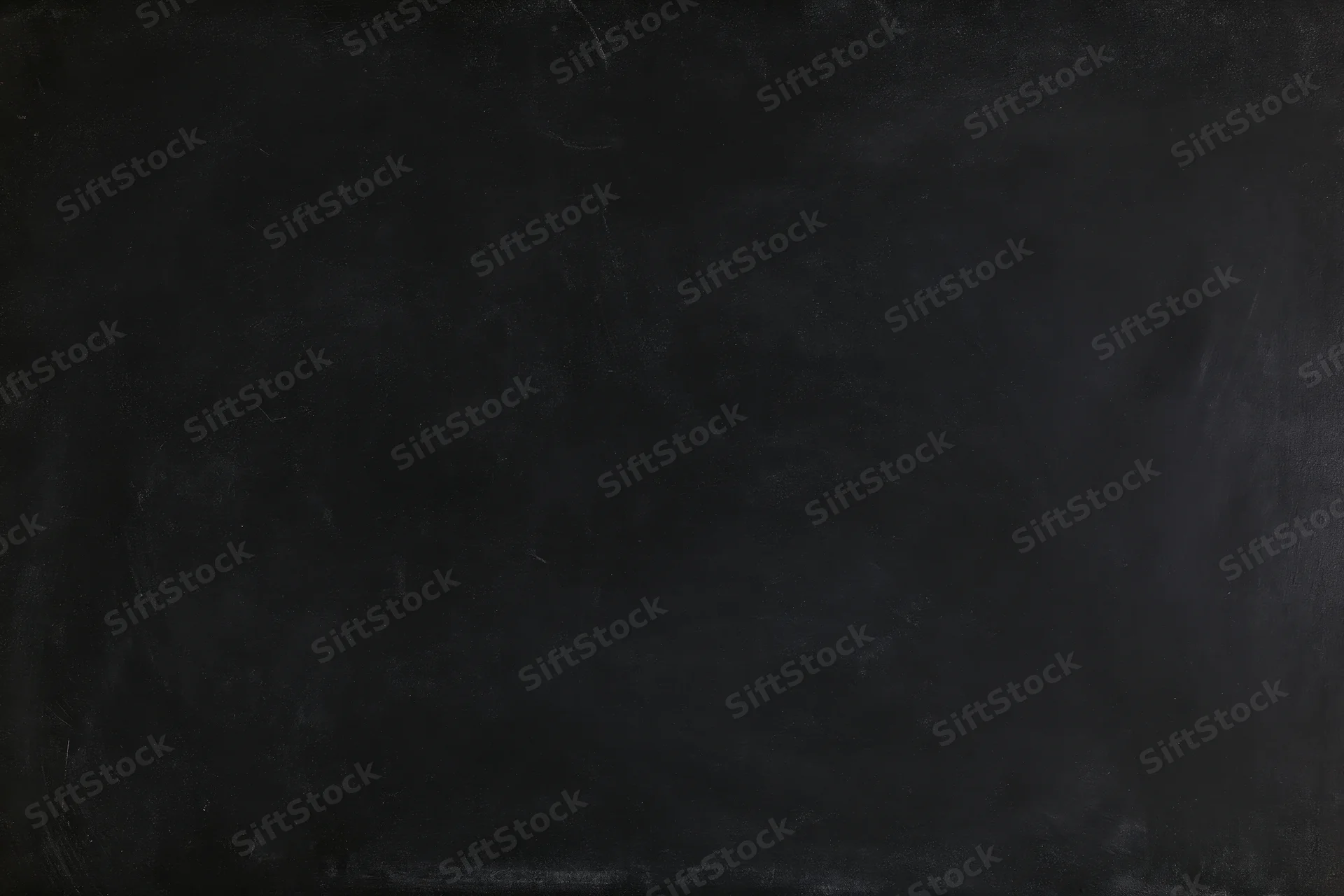 Close-up of a matte black chalkboard surface filling the frame with subtle texture and smudges