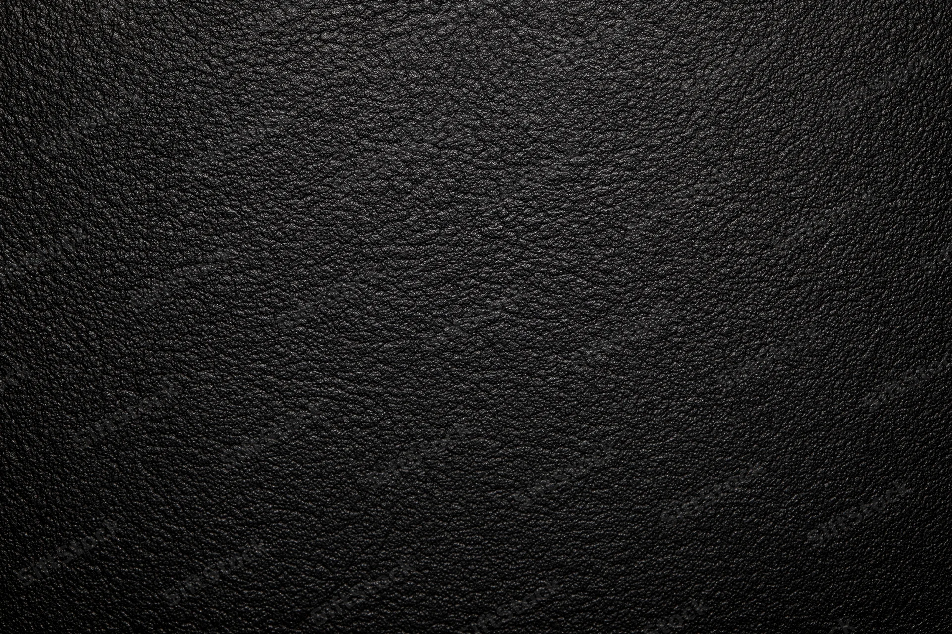 Close-up of black leather surface with visible grain texture filling the frame