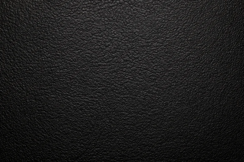 Close-up of black leather surface with visible grain texture filling the frame