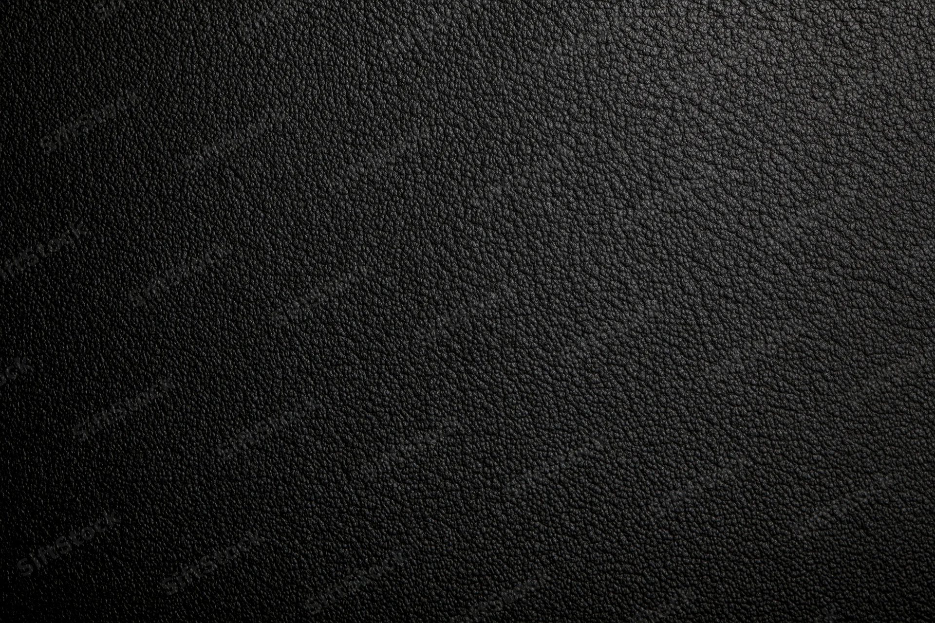 Close-up of black leather surface with pebbled texture filling the frame