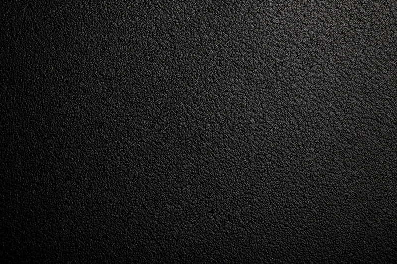 Close-up of black leather surface with pebbled texture filling the frame