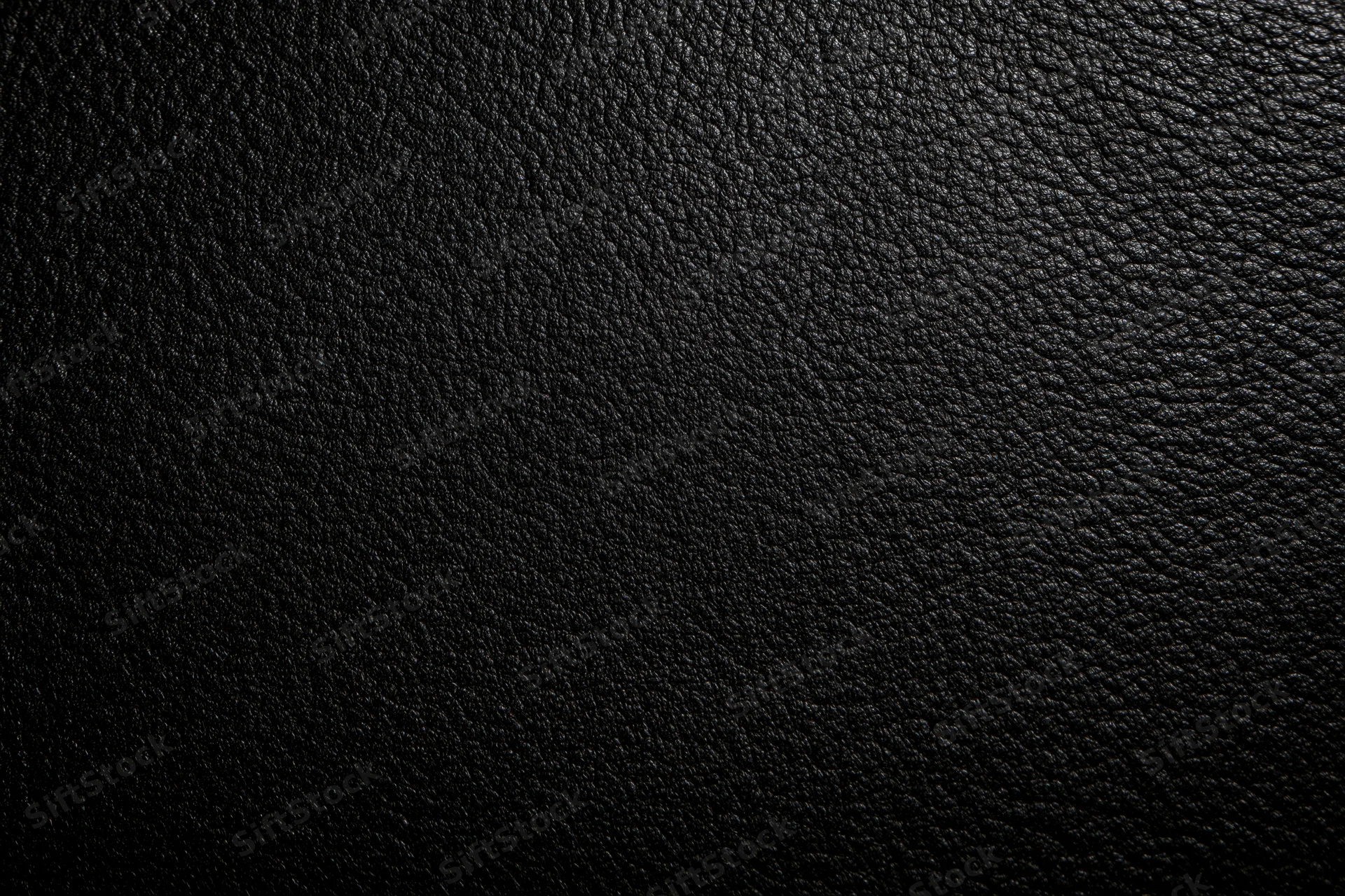 Close-up of black leather surface with visible grain texture filling the frame