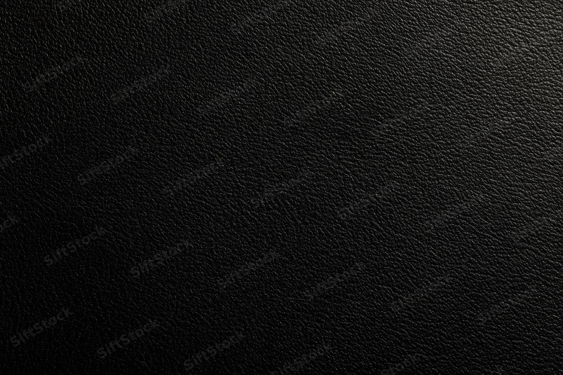 Close-up of black leather surface with visible grain texture filling the frame
