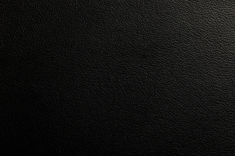 Close-up of black leather surface with visible grain texture filling the frame