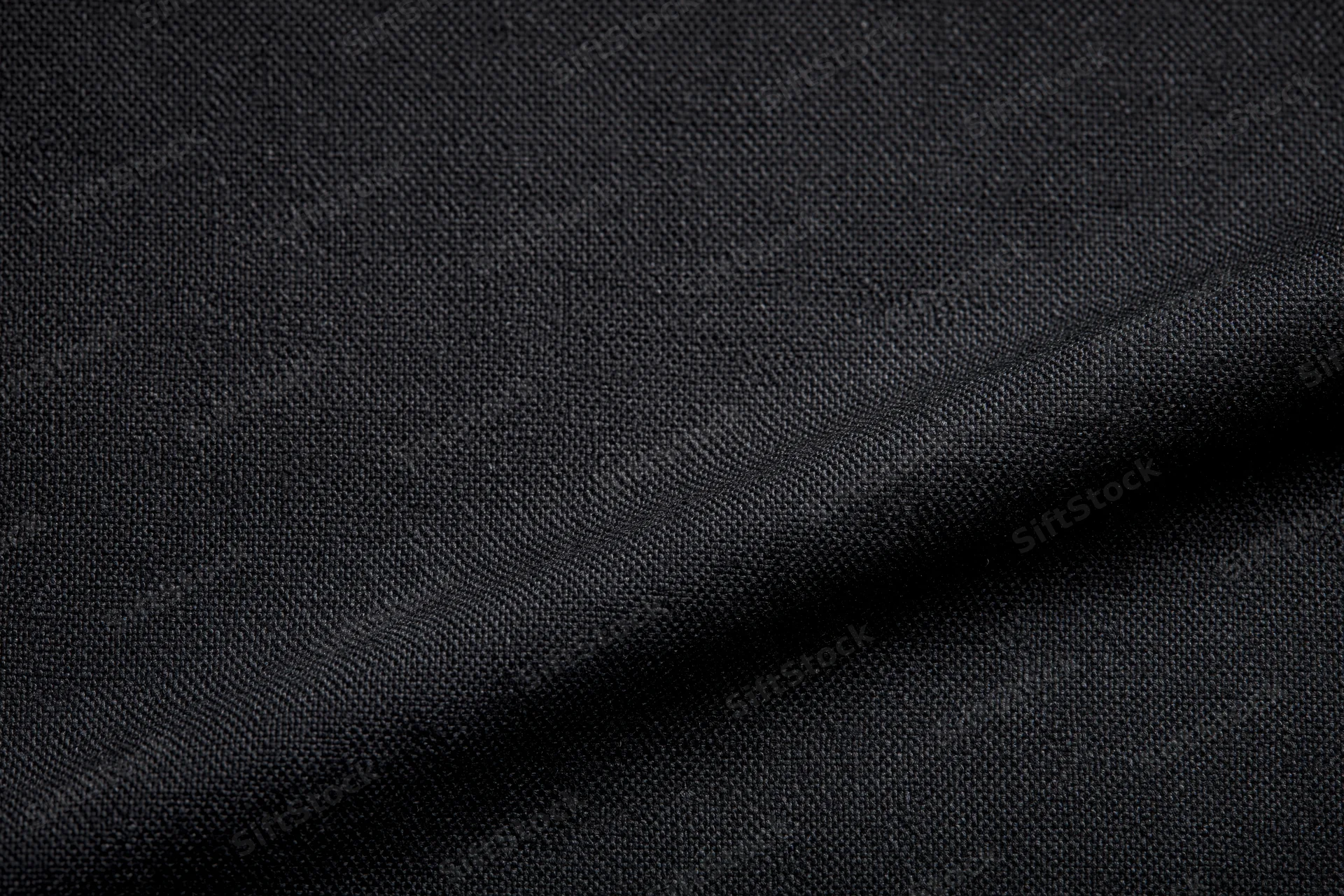 Close-up of black woven fabric with visible texture and folds filling the frame