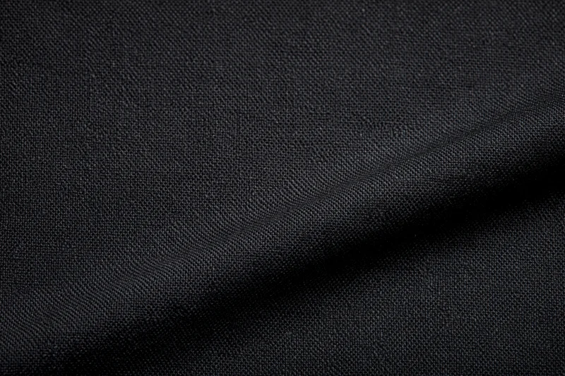 Close-up of black woven fabric with visible texture and folds filling the frame