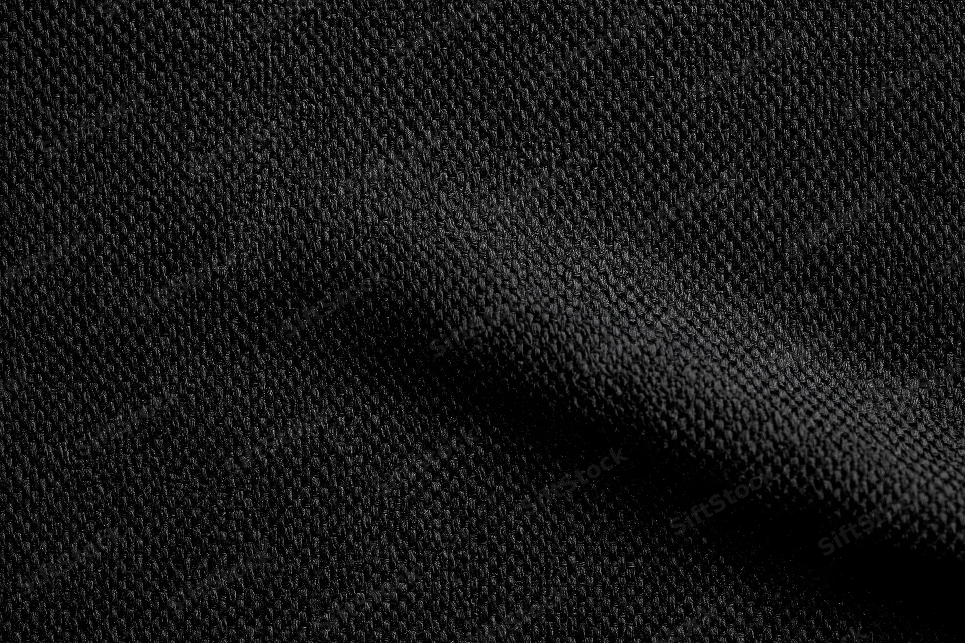 Close-up of black woven fabric with visible texture and folds filling the frame