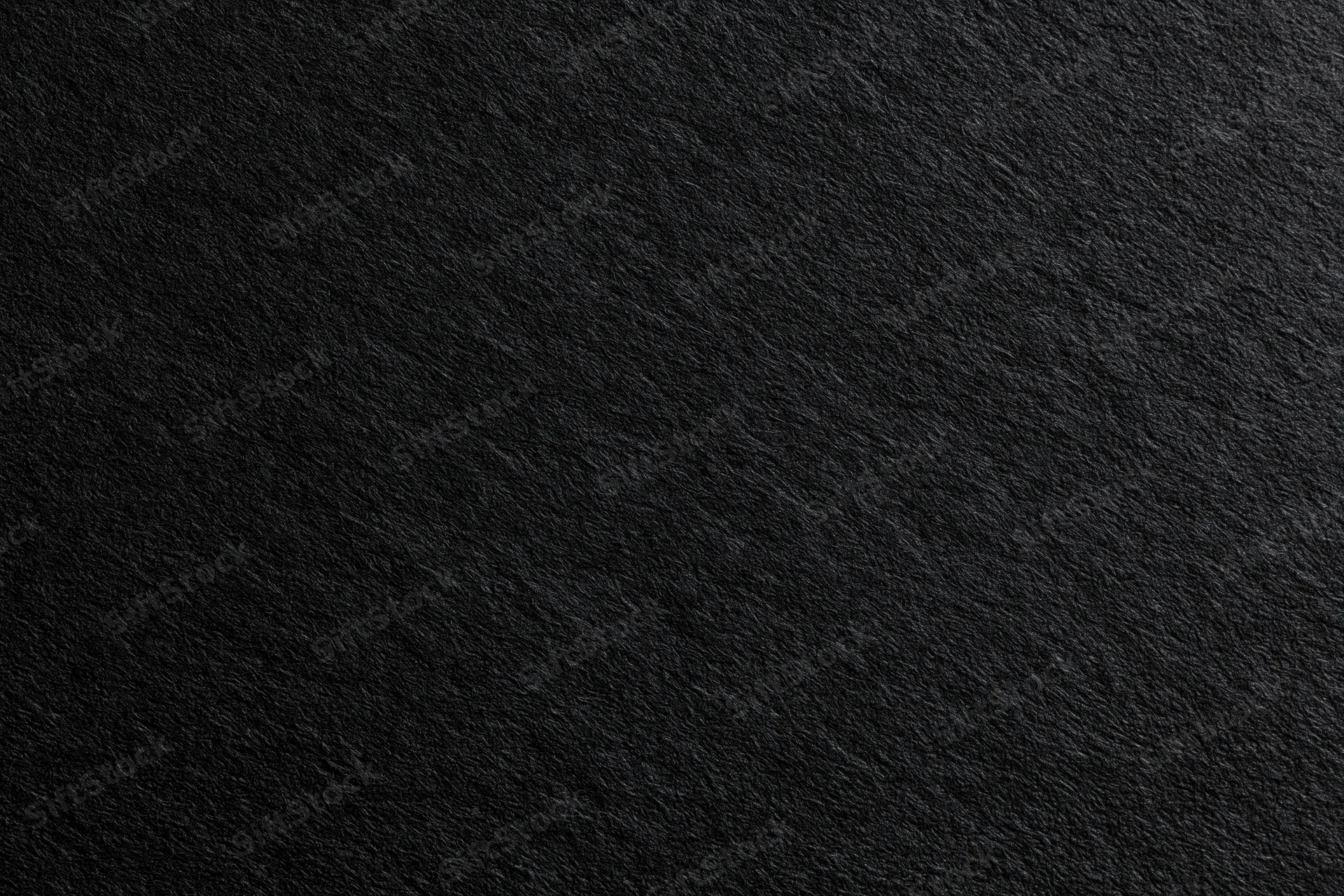 Close-up of dark charcoal black paper texture filling the frame