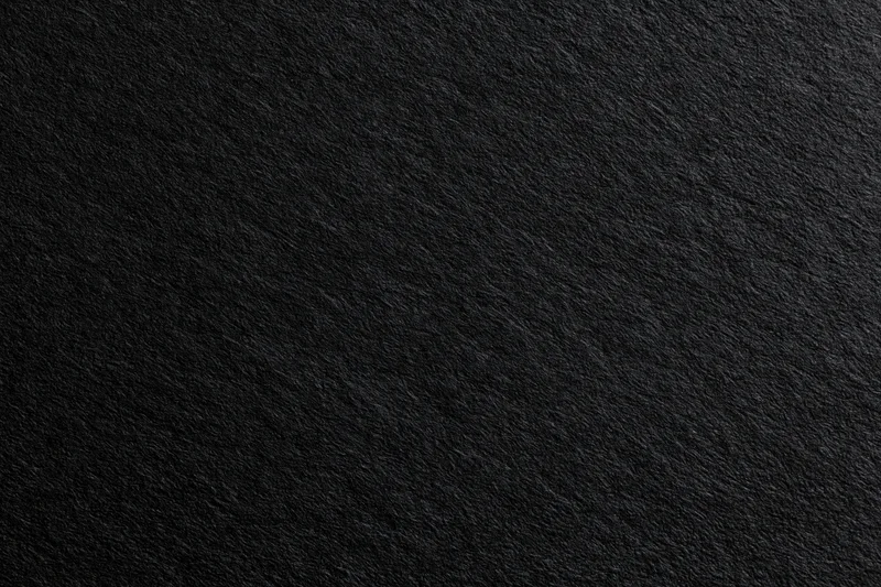 Close-up of dark charcoal black paper texture filling the frame