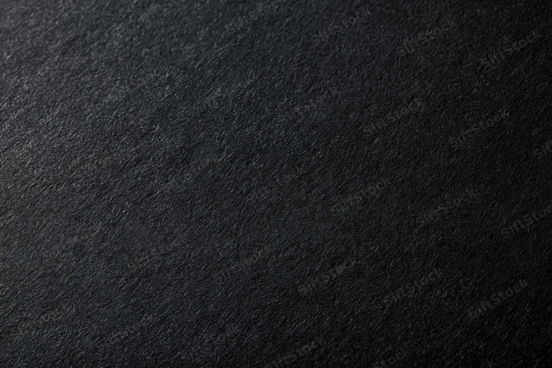 Close-up of dark charcoal black paper texture filling the frame