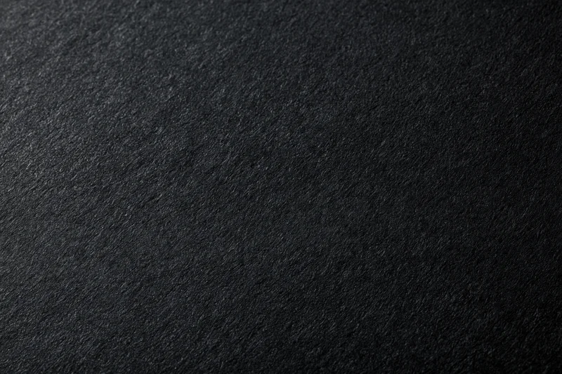 Close-up of dark charcoal black paper texture filling the frame