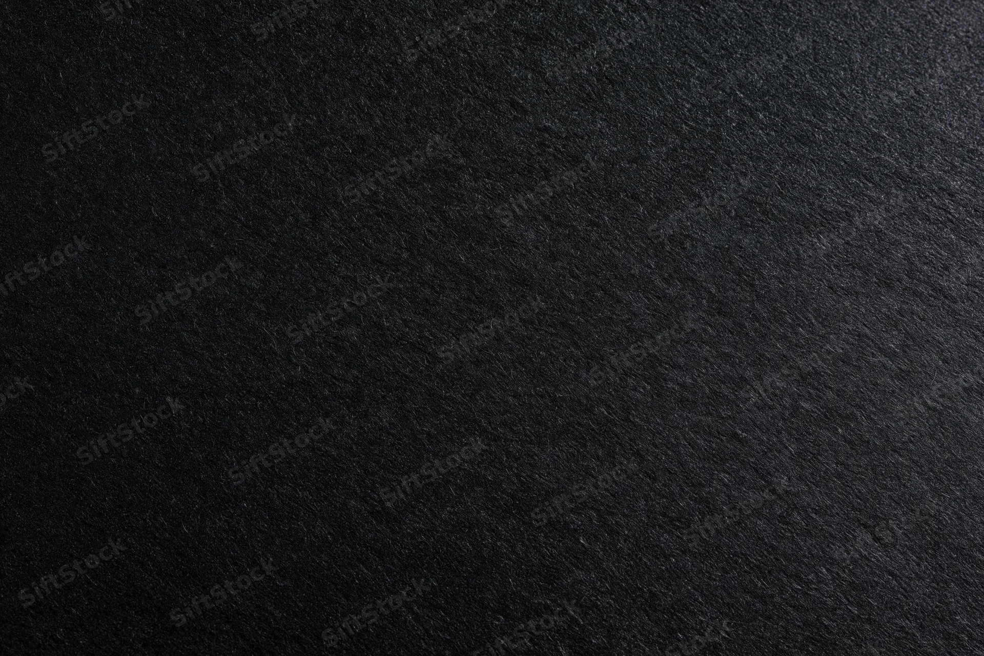 Close-up of dark charcoal black paper texture filling the frame